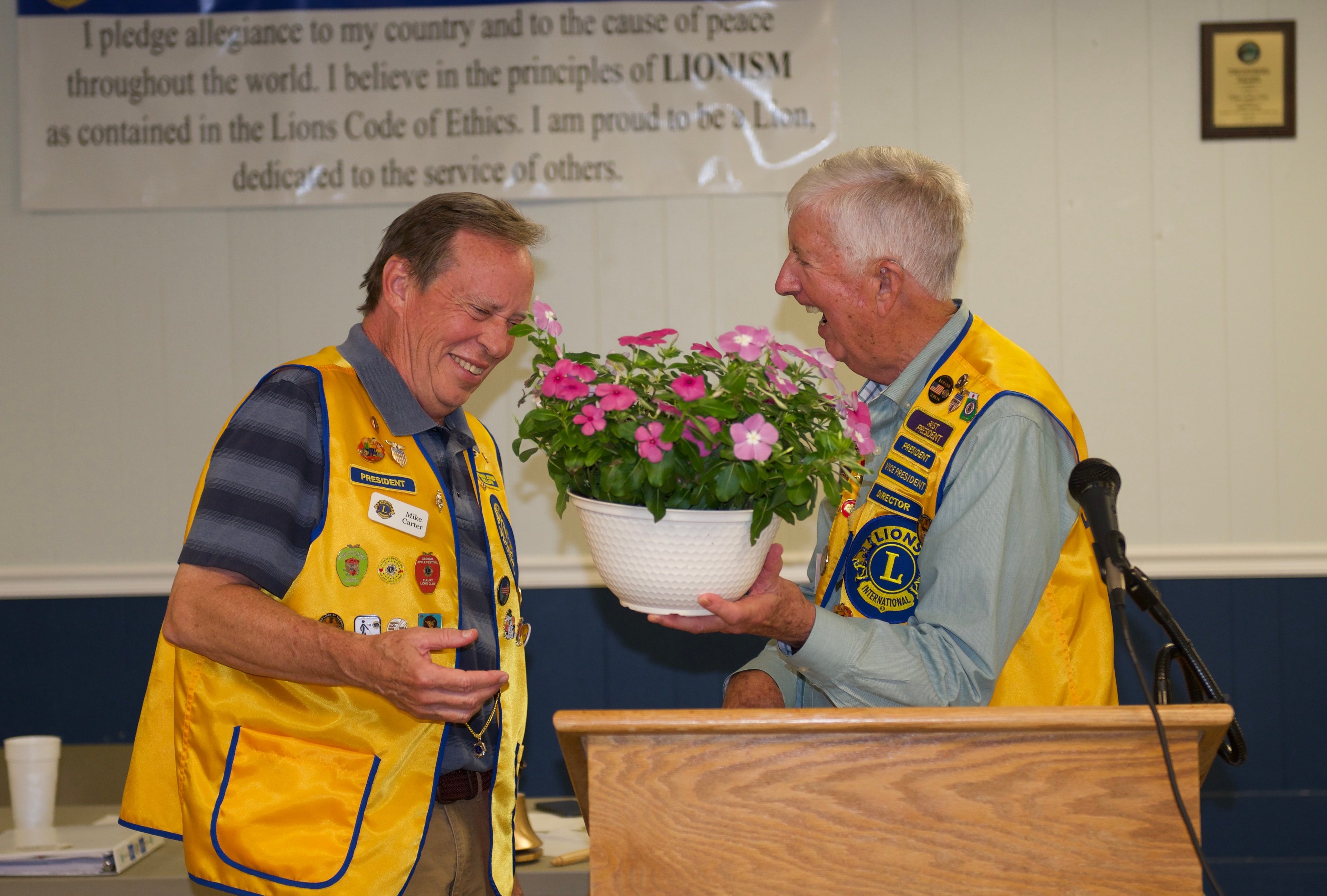 Two Lions Club members exchanging flowers at the ceremony