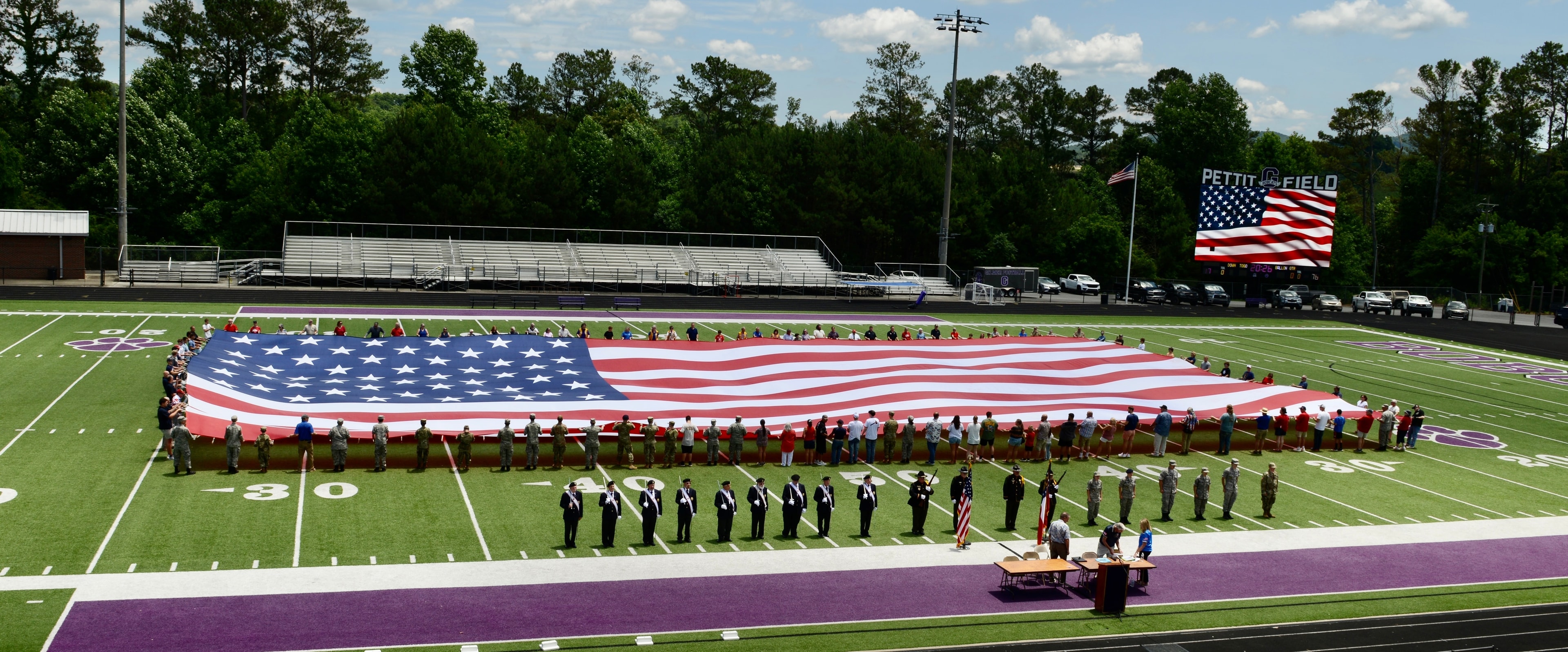 Giant 75 by 150 foot American flag fully unfurled on the field at Pettit Field stadium