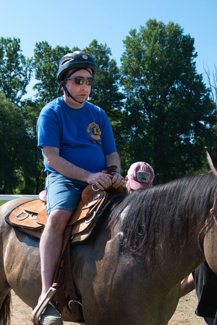 Man horseback riding with child at Special Friends