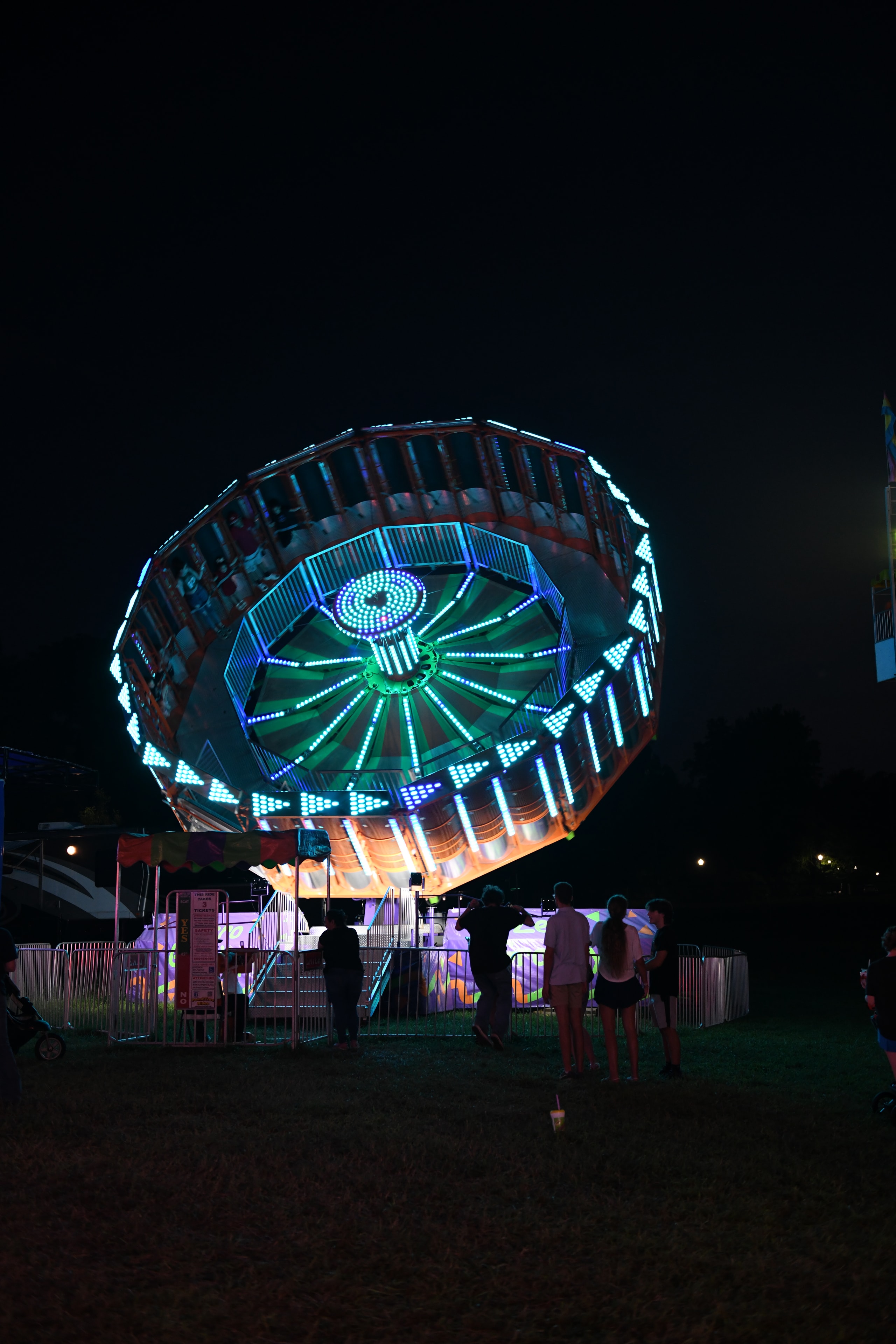 Illuminated carnival rides glowing at night at the Gilmer County Fair