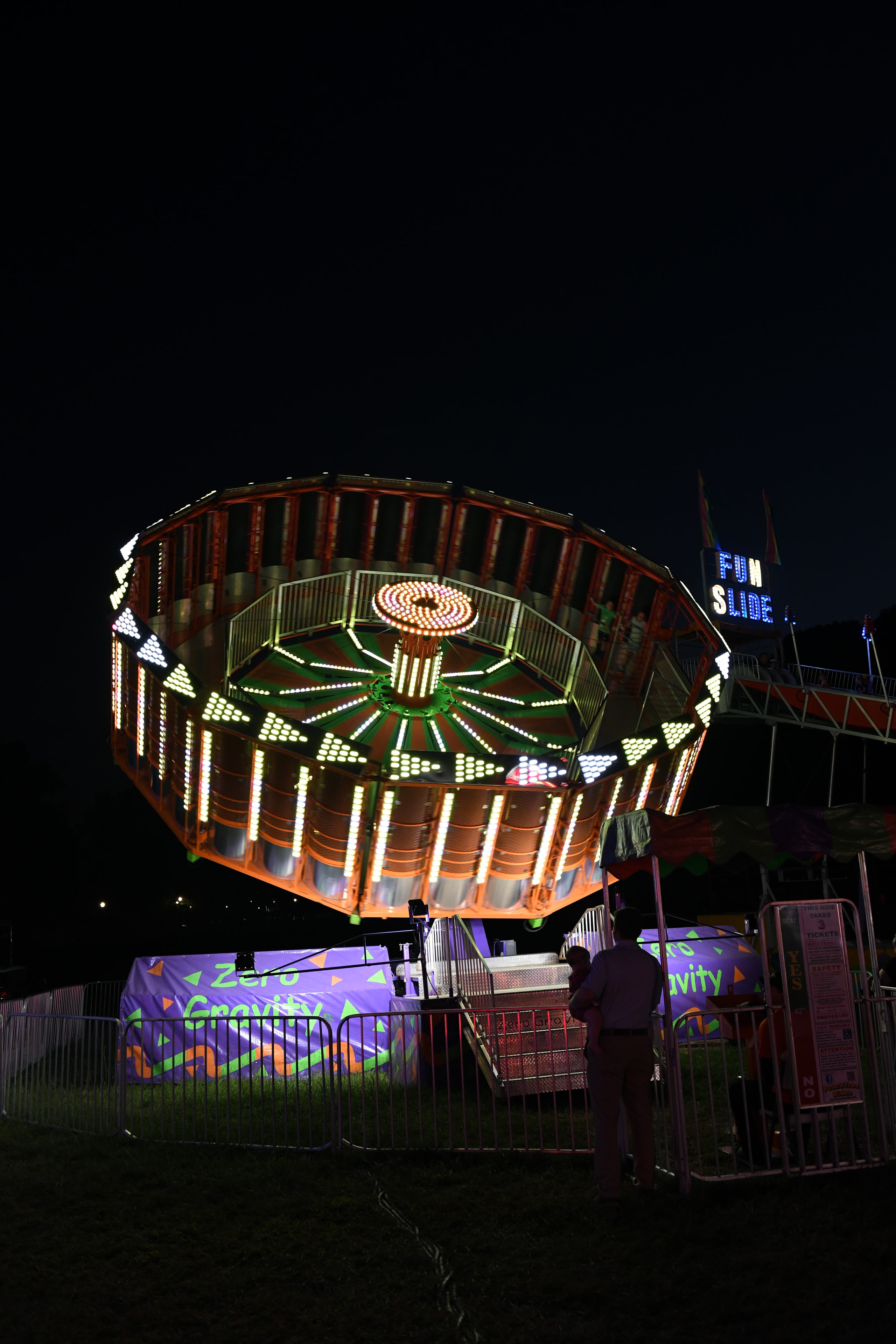 Illuminated zero gravity carnival ride at night at the Gilmer County Fair