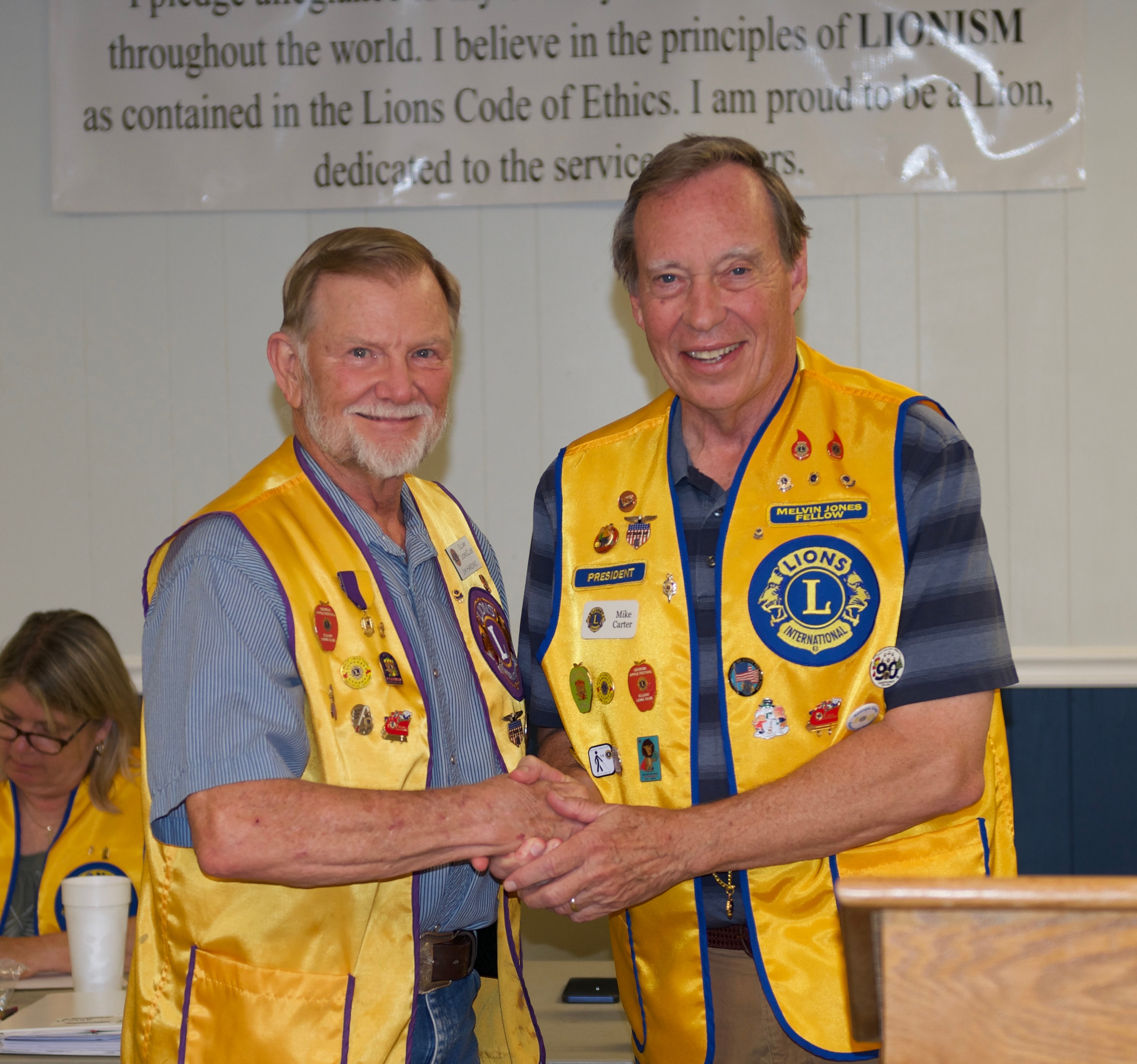Two Lions Club members shaking hands at the awards ceremony